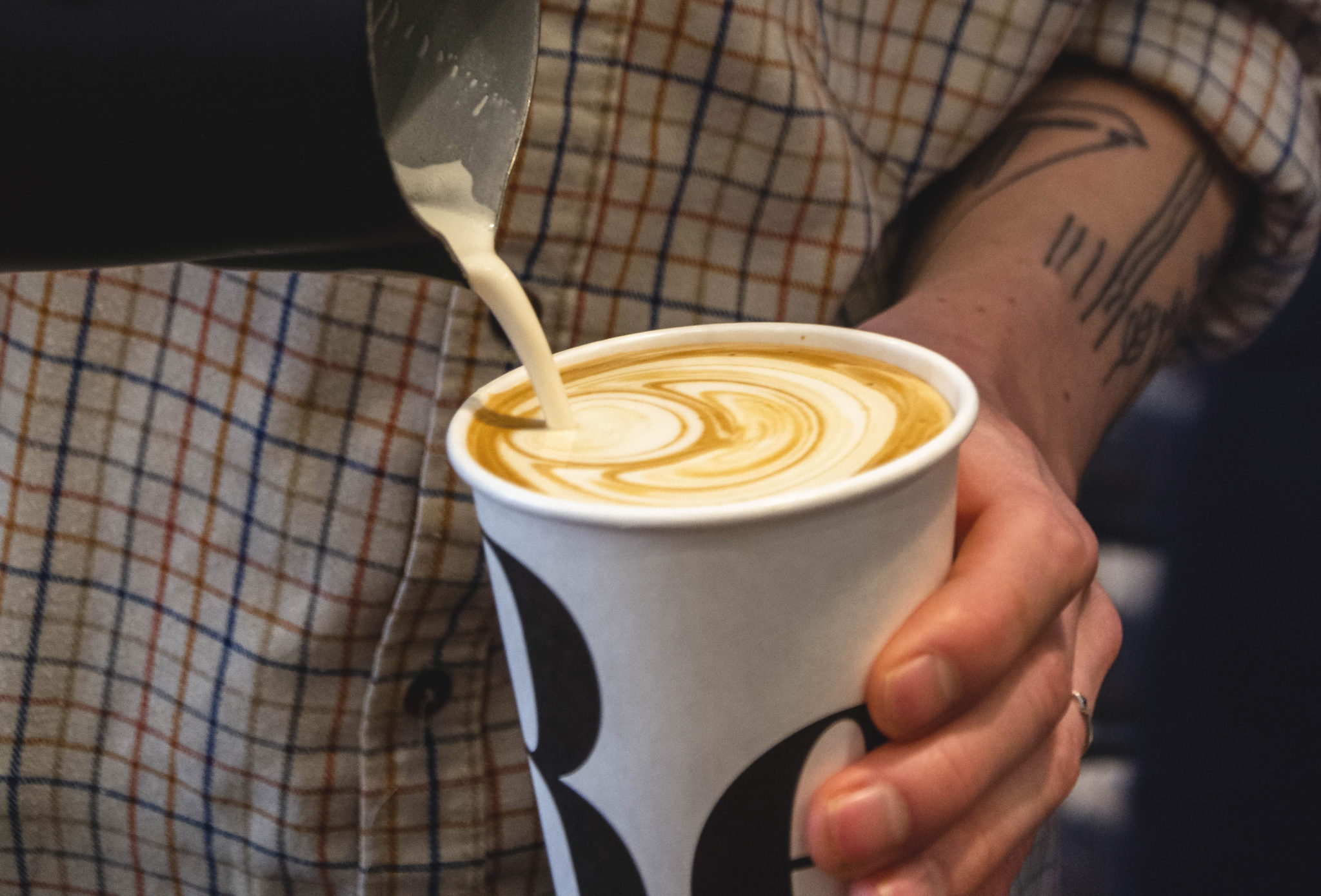 man pouring a latte